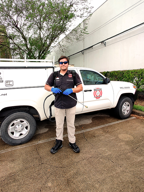 A Bulls Eye Pest Control Technician Standing Beside his Truck